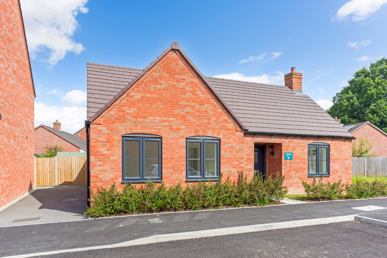 A red bricked bungalow with driveway