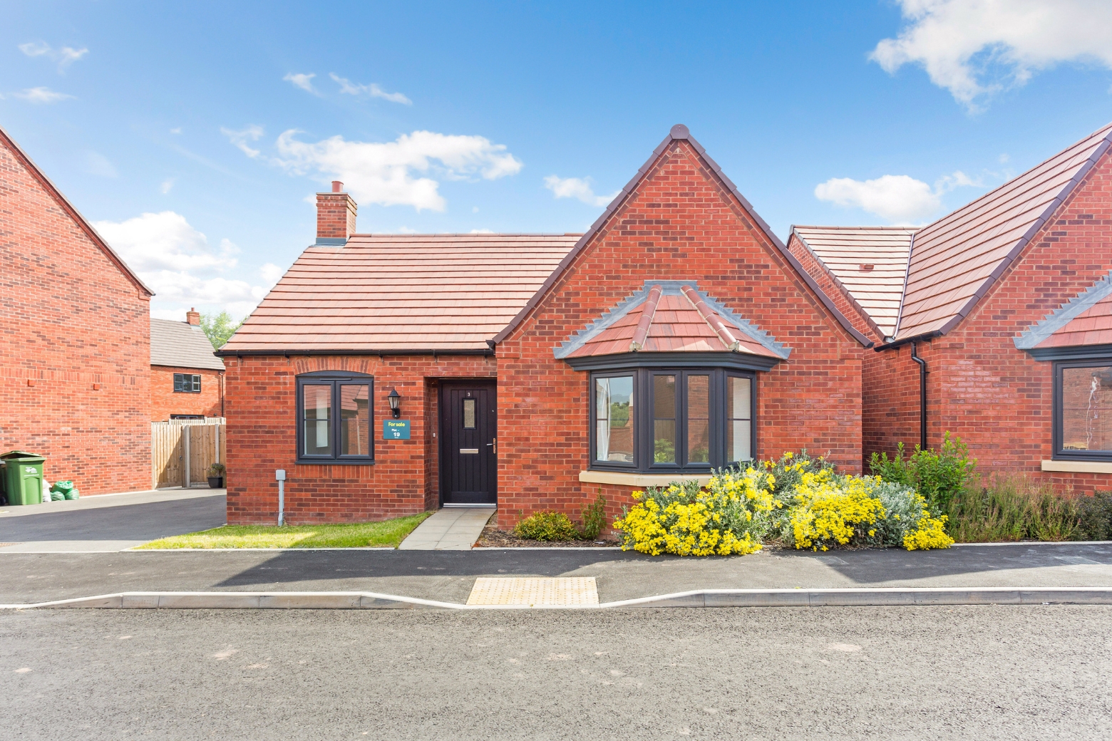 Front view of a red bricked bungalow with bay window