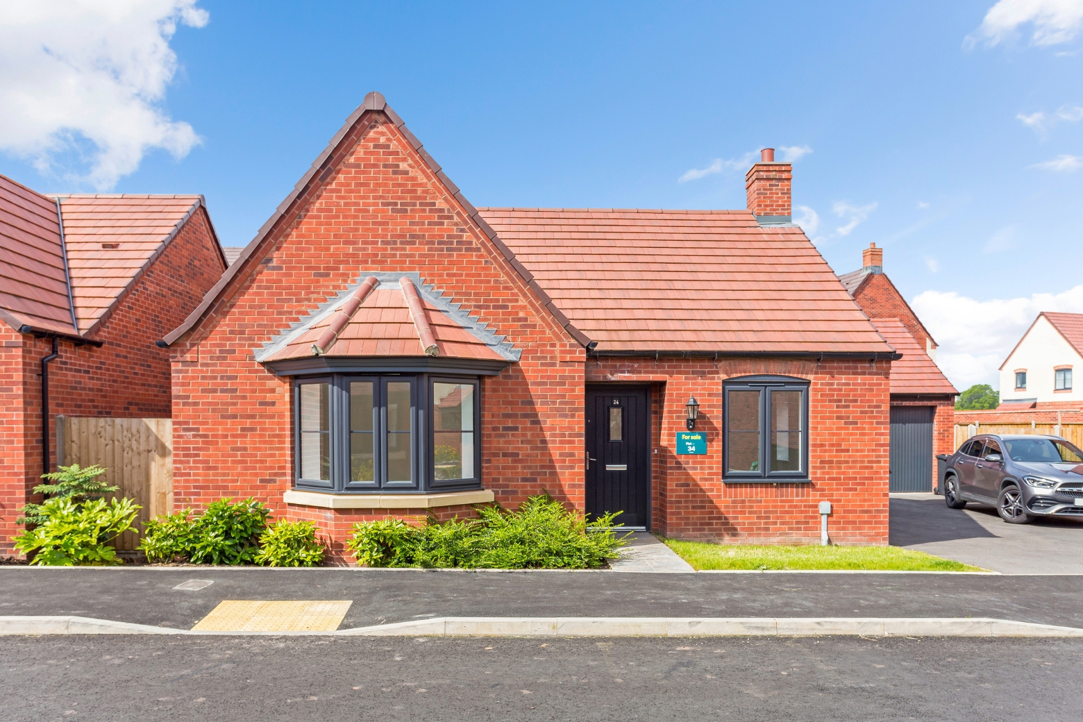 A red bricked bungalow with bay window at the front of the property