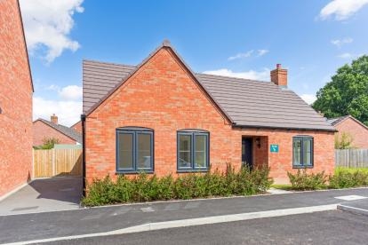 A red bricked bungalow with driveway