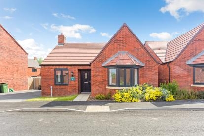 Front view of a red bricked bungalow with bay window