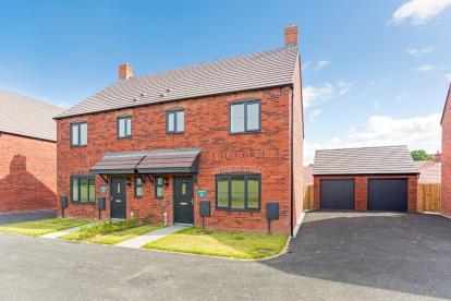 Two red bricked semi-detached houses with a driveway and garages either side and a small grassed garden to the front