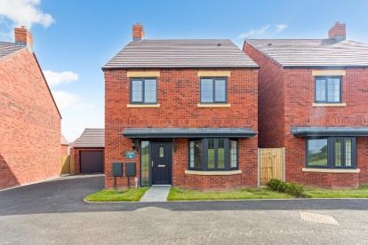 A red bricked detached home with bay window and driveway with the neighbouring house close next door