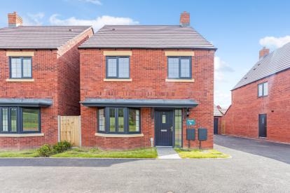 A red bricked detached home with bay window and driveway with the neighbouring house close next door