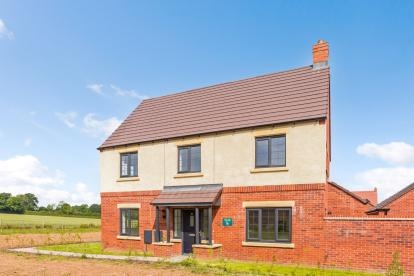 A double-fronted detached house with large grassed area to the side of the property